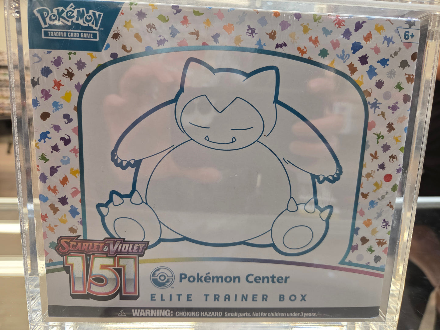 Pokémon trading card game box with cartoon character on a colorful Pokémon-themed background